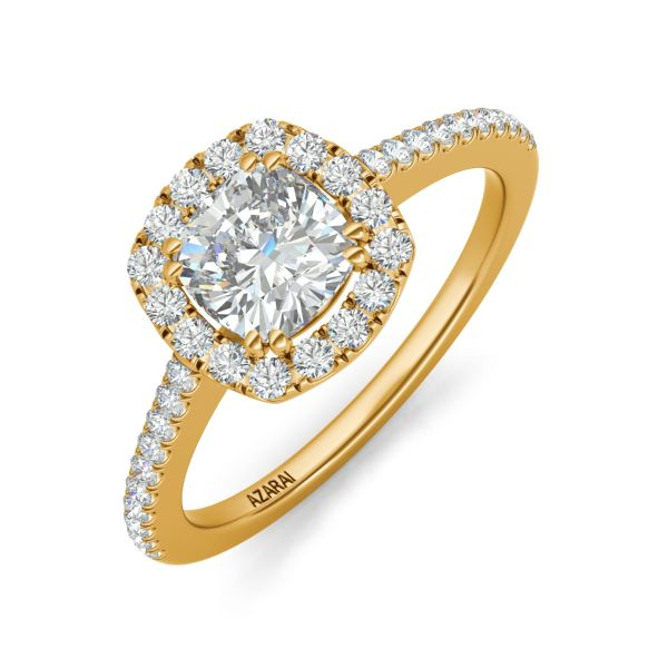 A yellow gold engagement ring with a cushion cut diamond.