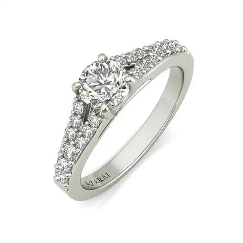 A white gold ring with a round-cut center diamond and smaller diamonds set along the band; "AZARAI" engraved inside.