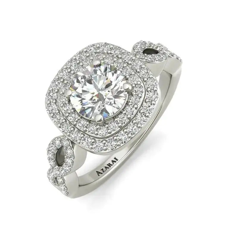 A silver ring with a large round central diamond, surrounded by two layers of smaller diamonds, and additional diamond accents on the band.