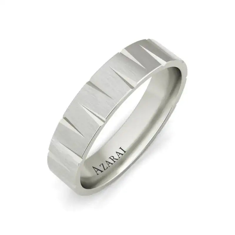 A silver ring with a brushed finish and vertical grooves, engraved with the word "AZARAI" on the inside band.