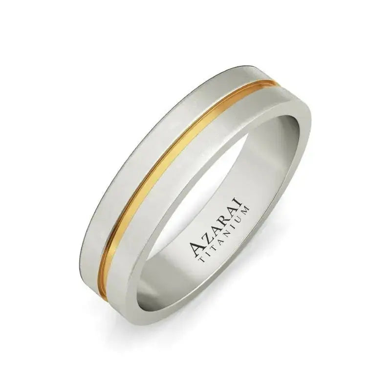 A titanium ring with a single gold-colored stripe running around its center and "AZARAN TITANIUM" engraved on the inner band.