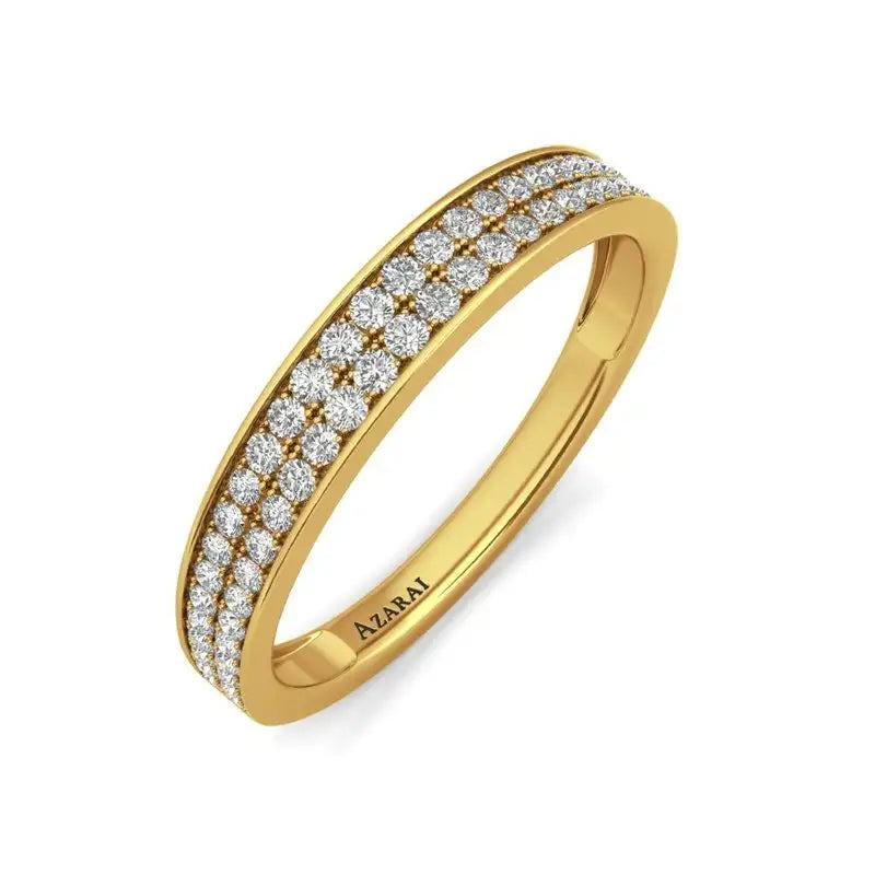 A gold ring with three rows of small, round diamonds set along the top, featuring the brand name "AZARAI" engraved inside the band.