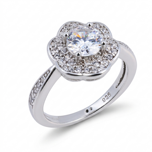 Introducing the Daisy sterling silver engagement ring, crafted in gleaming 925 sterling silver and showcasing a round central gemstone surrounded by smaller stones in an elegant floral motif evocative of a daisy. Additional sparkling stones are set along the band for extra brilliance, while the "925" stamp inside guarantees both authenticity and sophistication.
