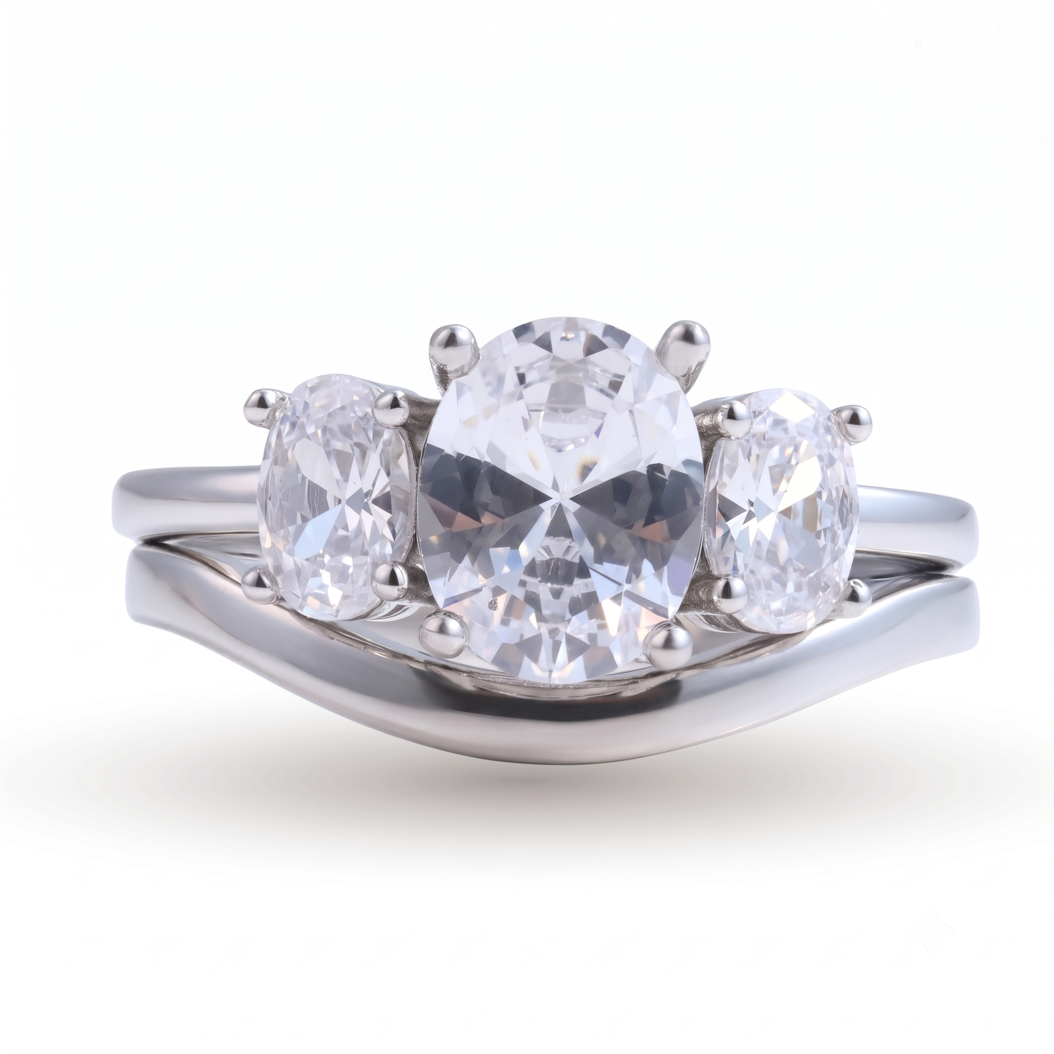 The Everly sterling silver engagement set features a three-stone oval diamond engagement ring with a curved matching band, both crafted in radiant sterling silver and elegantly displayed on a white background.