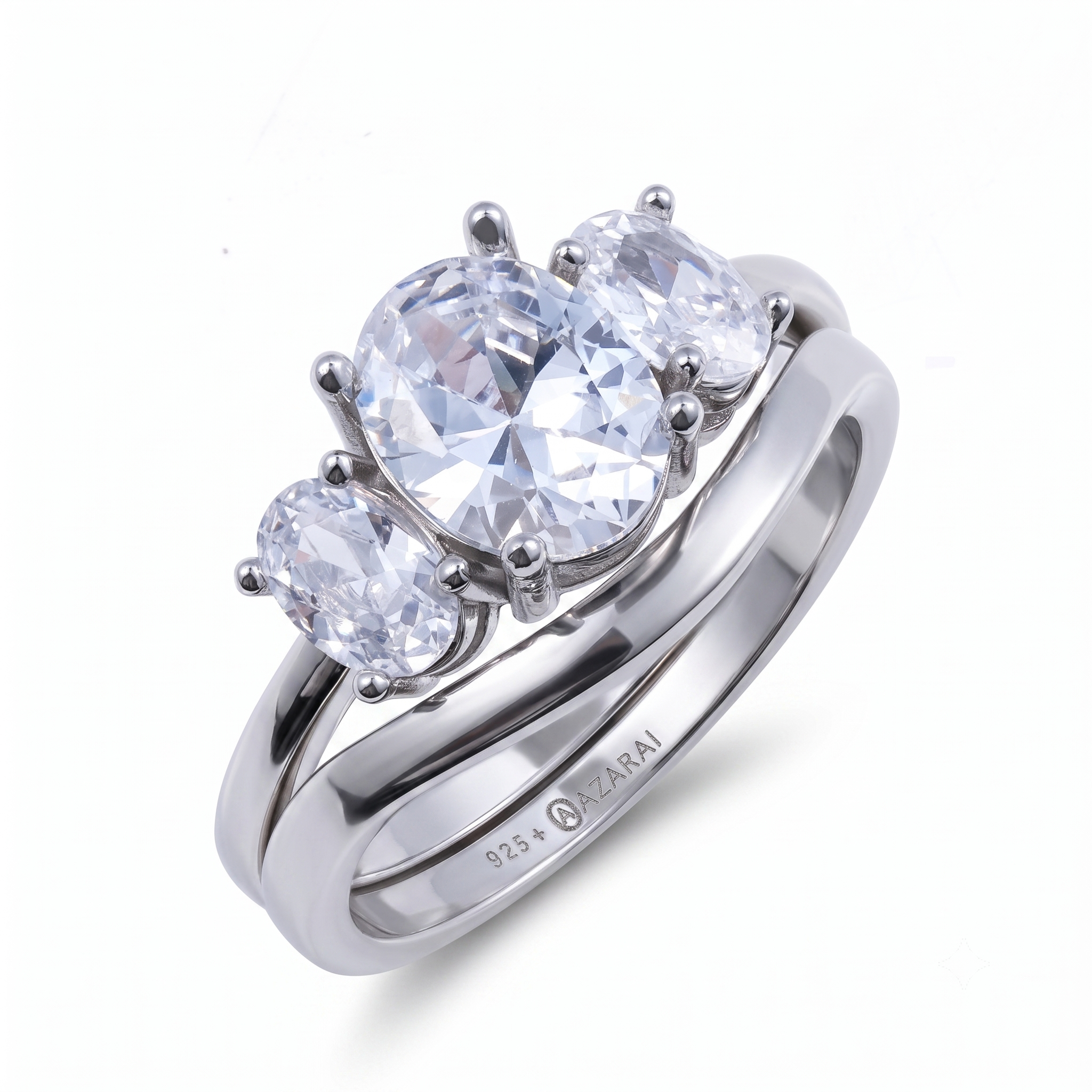 A stunning silver engagement ring from the Everly sterling silver engagement set, featuring three clear oval gemstones—a larger center stone flanked by two smaller side stones—and engraved with "925" and "NAZARI" on the inside band.