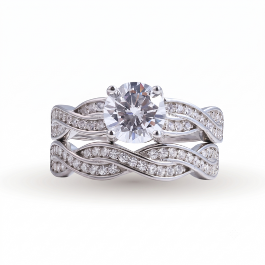 A captivating Jasmine sterling silver bridal set, this engagement and wedding ring duo features a round center diamond and wavy bands elegantly adorned with shimmering smaller diamonds.