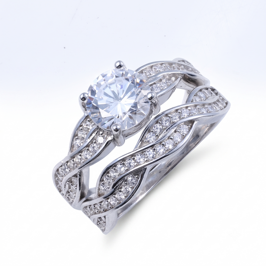 Introducing the Jasmine sterling silver bridal set, featuring a large round central stone and an intertwined band design adorned with smaller stones—an exquisite choice for pairing as a bridal set or enhancing the elegance of your collection.