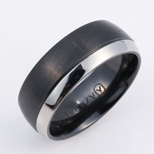 The Oakland black titanium wedding band, featuring a matte black finish with a polished silver edge and engraved with "ALAZA ANG" on the inside, is displayed against a plain white background.