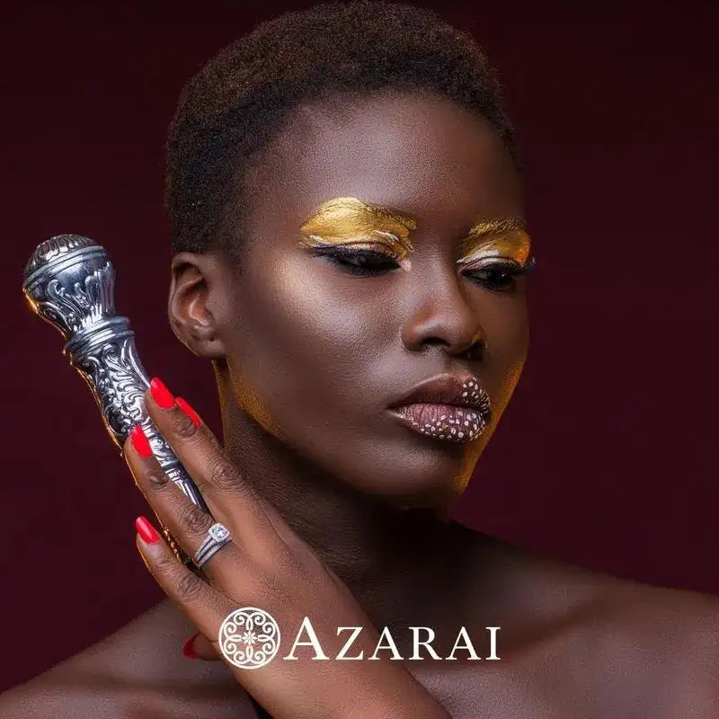 A woman with gold eye makeup and decorative lipstick holds the Eva sterling silver bridal set near her face, with "AZARAI" and its logo displayed at the bottom.