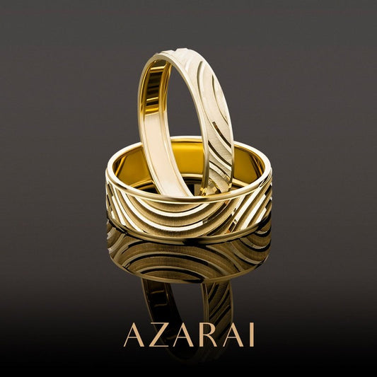 A pair of Contour 9kt gold men's wedding bands with the word azarai engraved on them.