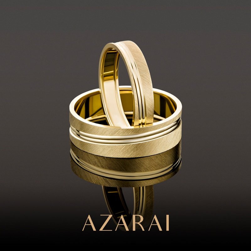 A pair of Sherwood 9kt gold men's wedding bands with the words azari.