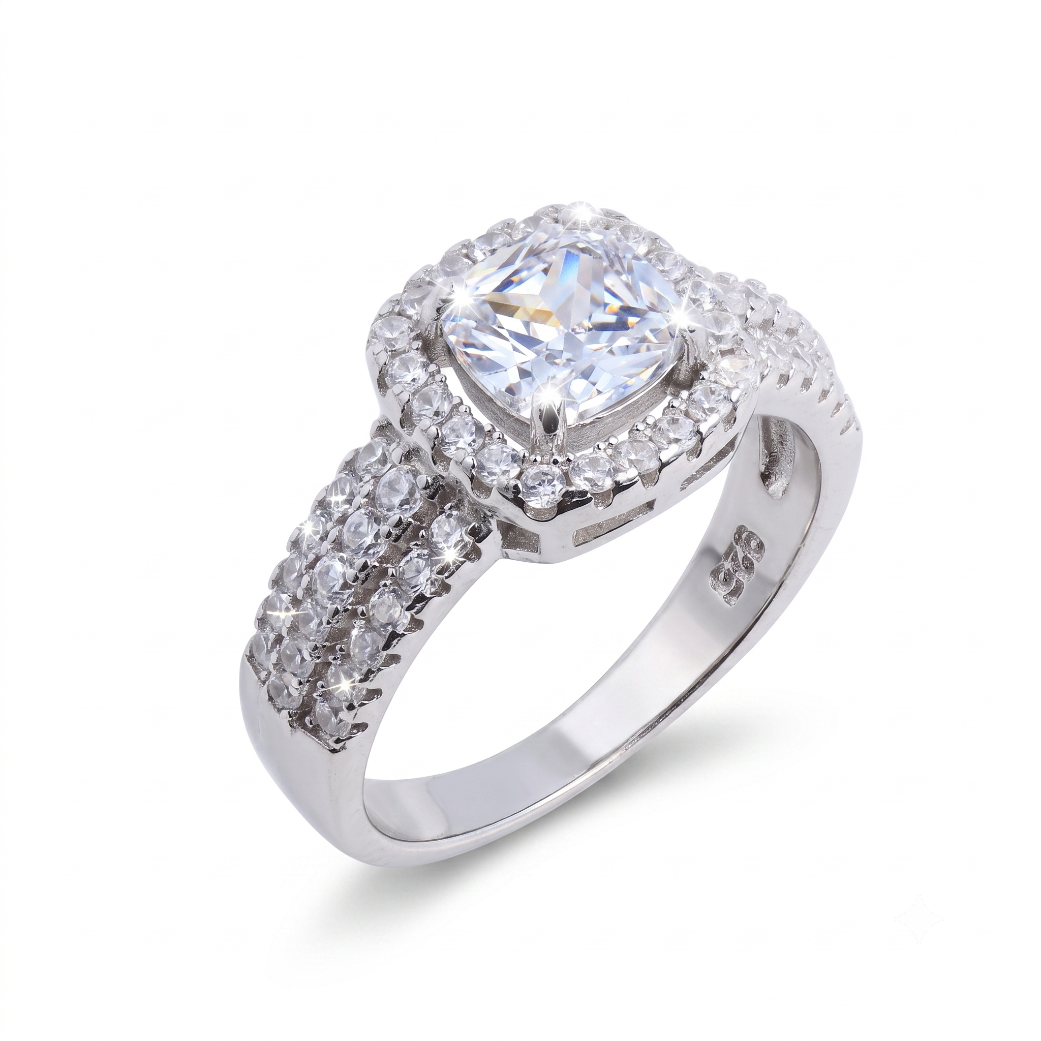 The Raelynn sterling silver engagement ring showcases a cushion-cut central gemstone, encircled by smaller clear stones and complemented by a band adorned with additional clear stones.
