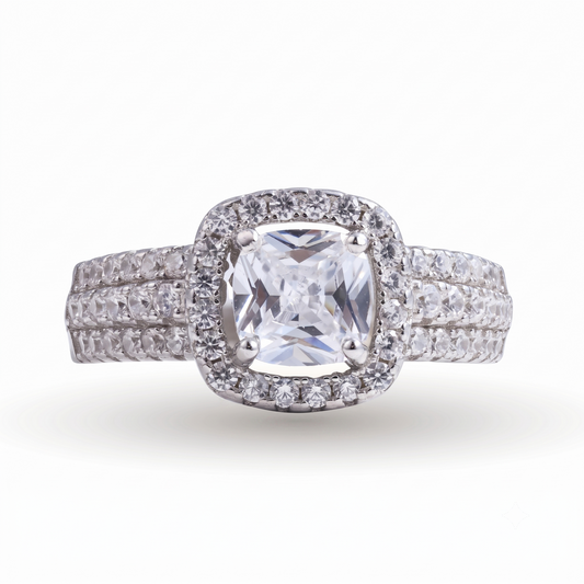 The Raelynn sterling silver engagement ring showcases a striking square-cut center diamond, accented by a halo of smaller diamonds and set on a double band adorned with sparkling stones.