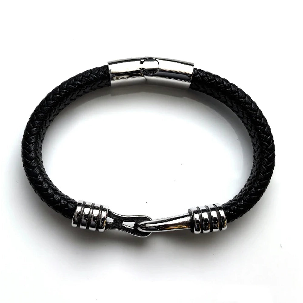 The Stirrup Braided Leather Men's Bracelet features black braided leather, silver accents, and a stainless steel clasp, shown on a white background.