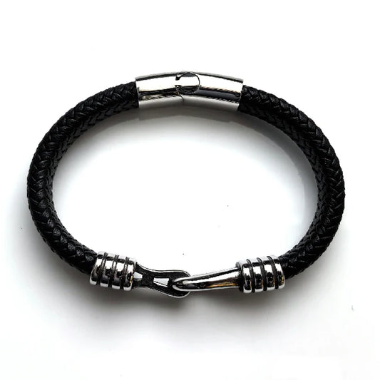 The Stirrup Braided Leather Men's Bracelet features black braided leather, silver accents, and a stainless steel clasp, shown on a white background.
