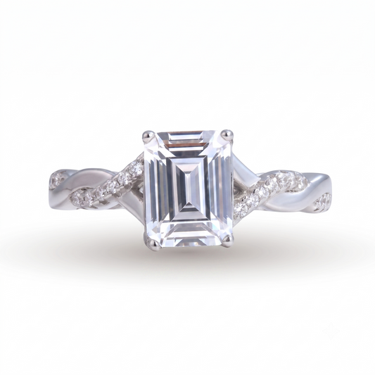 Sia Emerald sterling silver engagement ring featuring a large emerald-cut clear gemstone and small round diamonds set in a twisted band design, shown on a white background.