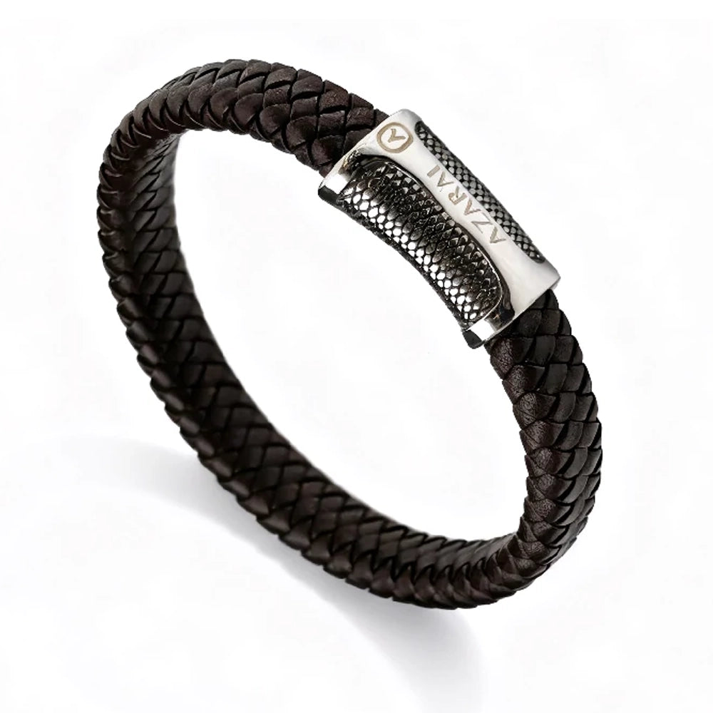 The Treso Braided Leather Men's Bracelet showcases dark brown braided leather and a textured metal clasp engraved with "ATAMAN" and a small circular logo.