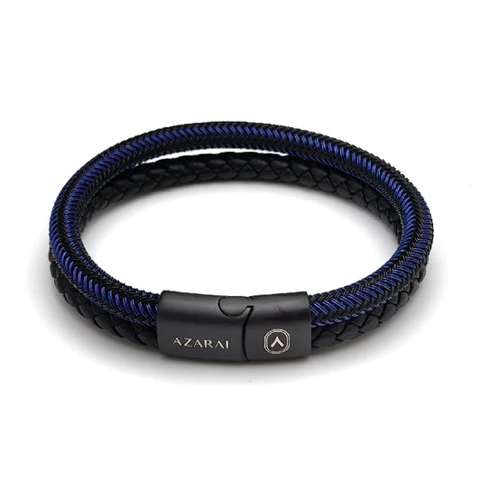 The Velocity Braided Leather Men's Bracelet features black and blue braided leather, a sleek black magnetic clasp engraved with "AZARAI" and a shield logo. This stylish multi-strand accessory adds modern flair to any outfit.