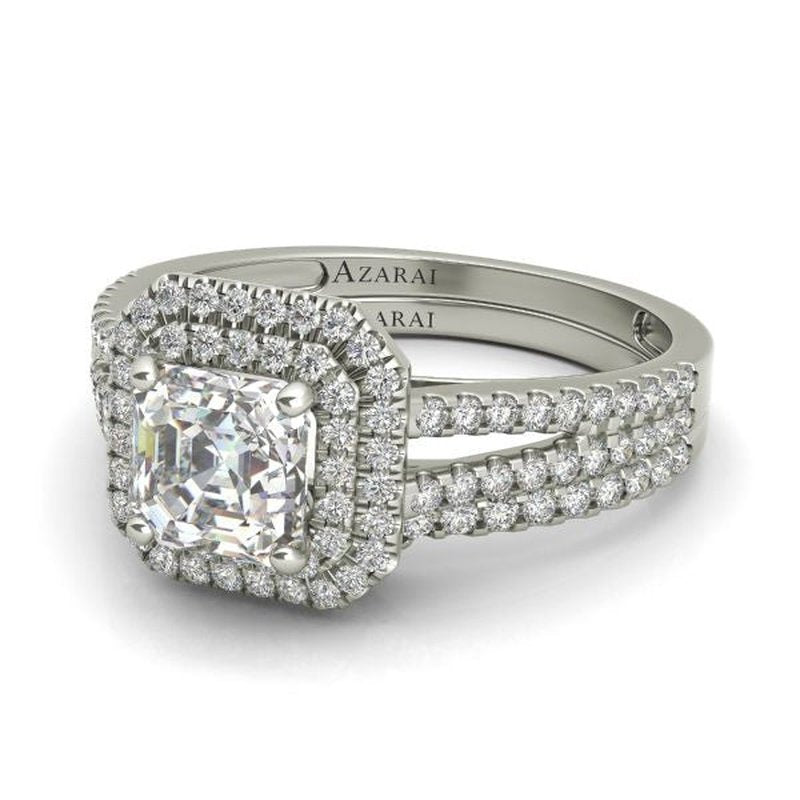 A silver engagement ring featuring a large square-cut central diamond surrounded by a double halo of smaller diamonds, with additional diamonds set along the Beatrix 9kt gold bridal set band.