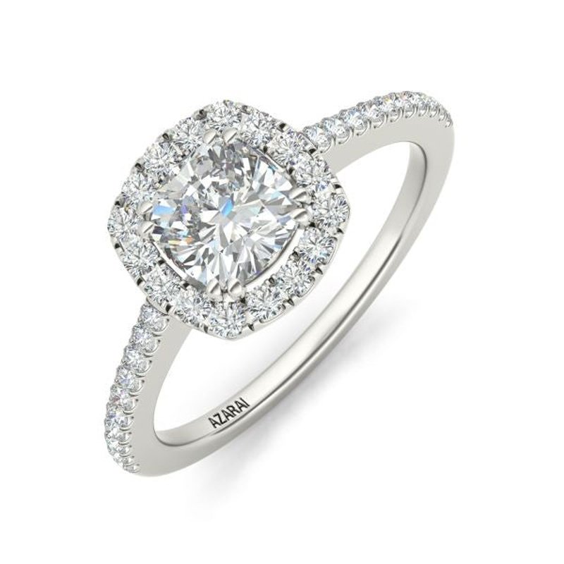 A Celeste 9kt gold engagement ring featuring a large, central cushion-cut diamond surrounded by a halo of smaller diamonds, set on a pave band.